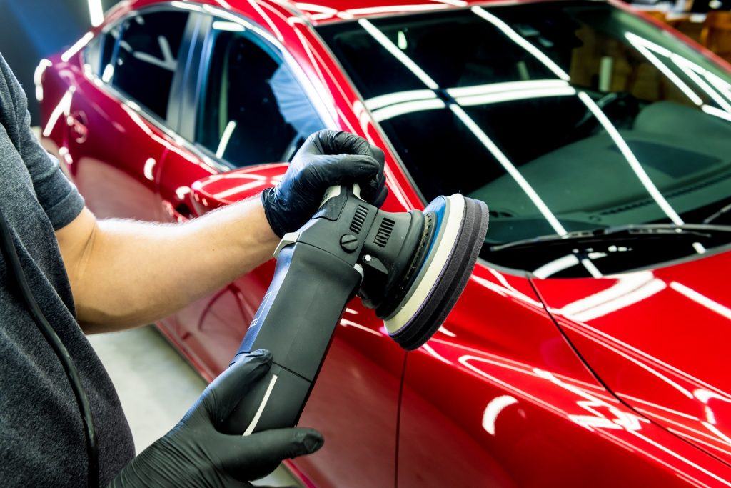 a man polishing a red car for ceramic coating process at loves auto details in kapolei Hawaii